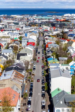 Reykjavik, İzlanda, 14.05.22. Reykjavik simetrik şehir merkezi Skolavordustigur caddesi boyunca renkli binalar ve sonunda Gökkuşağı Sokağı, Hallgrimskirkja kilise kulesinden görülüyor..