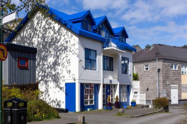 İzlanda 'nın Reykjavik şehrinde, mavi gable çatılı modern İzlanda evi, beyaz taş cephe ve yurt pencereleri.