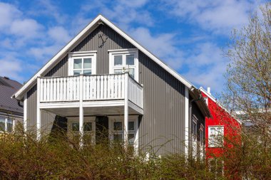 Reykjavik, İzlanda 'da geleneksel İzlanda yerleşim yeri çatılı, beyaz pencere çerçeveli, beyaz ahşap balkon, kıvrımlı metal levhalarla kaplı..