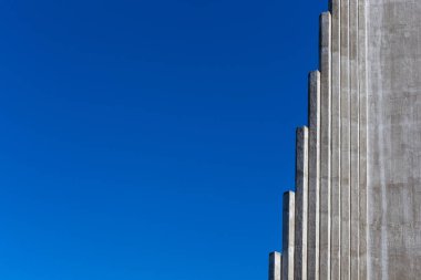 Grey pillars in ascending order as steps, close-up view of the Hallgrimskirkja Church facade, Reykjavik, Iceland, copy space, blue sky, climbing, rising concept. clipart
