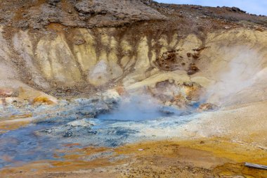 Krisuvik 'teki Seltun Jeotermal Alanı, kaynayan sıcak pınarları ve kükürt toprağının turuncu ve mavi renkleri ile İzlanda.