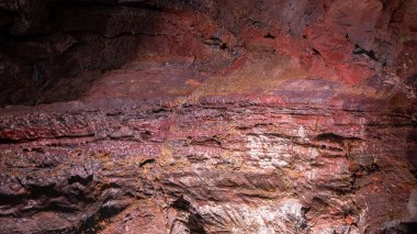Lava Tüneli Duvarı (Raufarholshellir), İzlanda 'daki kırmızı ve kahverengi demir volkanik kayaların yakın görüntüsü..