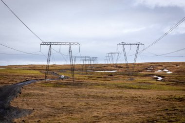 Güney İzlanda 'nın çayırlarında yüksek voltaj iletim kuleleri ve hatları var..
