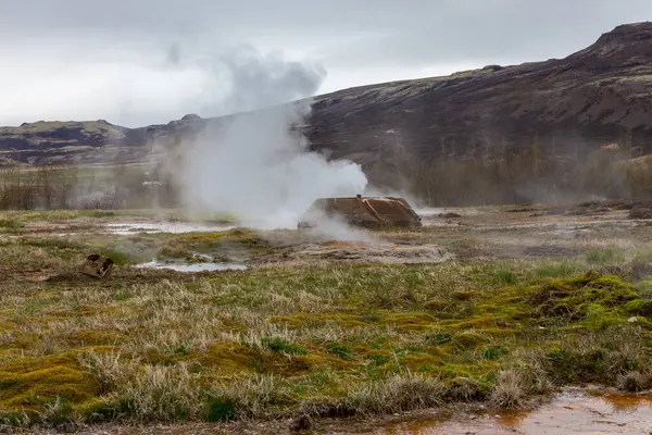 Haukadüler Vadisi, İzlanda 'daki Geysir Jeotermal Alanı' nın kaynayan kaplıcaları, sıcak su akıntıları ve arka planda dağları var..