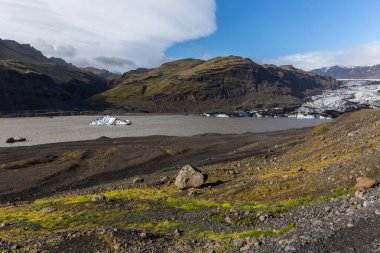 Solheimajokull, Myrdalsjokull buzulunun bir parçası, yüzen mavi buzdağları ve ham dağ manzarası olan buzul gölü, İzlanda.