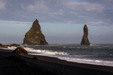 Reynisdrangar bazalt deniz yığınları Reynisfjara Kara Kum Sahili, İzlanda 'da sinsi dalgalar kıyıya çarpıyor..
