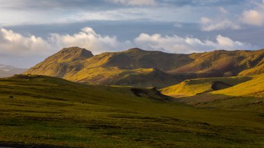Güney İzlanda dağ manzarası Vik i Myrdal köyleri volkanik dağ yosunlarıyla kaplı, gün batımı manzaralı.