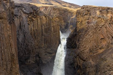 Litlanesfoss (Studlabergsfoss) waterfall in Hengifossa in Fljotsdalur, Eastern Iceland with hexagonal basalt columns rock formations. clipart