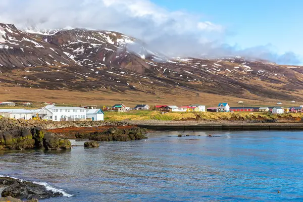 stock image East fjords coastline landscape with colorful Bakkagerdi village and snowcapped mountains in spring, Iceland.