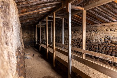 The turf houses of Hjardarhagi farm (Torfhusin I Hjardarhaga) inside view of traditional sheephouse with sheep feeding line, Iceland. clipart