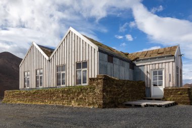 Geleneksel İzlanda ahşap binası. Çim kaplı çatı, gri ahşap paneller..