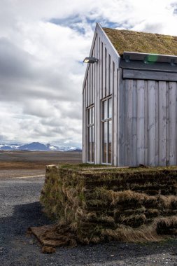 Geleneksel İzlanda ahşap binası. Çim kaplı çatı, gri ahşap paneller..