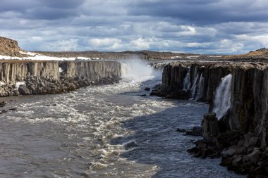 Jokulsa 'da selfoss şelalesi Fjollum nehri, kanyon manzarası bazalt sütunlar ve bulutlu gökyüzü, İzlanda.
