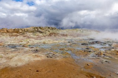 Kuzey İzlanda 'nın Hver, Myvatn Jeotermal Bölgesi' nde kaynamış ve buharlaşmış gri çamur kapları ve turuncu sülfür toprağı..