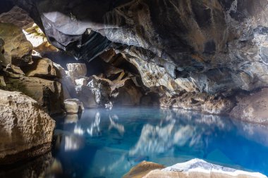 Grjotagja, kristal mavi sıcak su kaynağı ve kaya oluşumlarıyla küçük bir lav mağarası, Kuzey İzlanda 'da Myvatn Jeotermal Bölgesi.