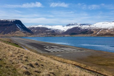 Westfjords, İzlanda 'da 26 numaralı havaalanı pisti eşik ve touchdown bölgesi. Arka planda karlı dağlar ve fiyort körfezi var..