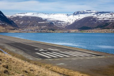 Westfjords, İzlanda 'da 26 numaralı havaalanı pisti eşik ve touchdown bölgesi. Arka planda karlı dağlar ve fiyort körfezi var.. 