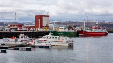 Patreksfjordur, Westfjords, İzlanda, 24.05.22. Limana yanaşan feribotlar, balıkçı tekneleri ve gemiler, liman, nakliye, lojistik tesisleri ve hangarlarla birlikte liman manzarası.