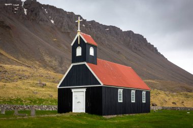 Sauraejarkirkja (Sauraejar Kilisesi) siyah ahşap cephe ve kırmızı çatılı, Westfjords, İzlanda 'daki Raudisandur plajının yanında..