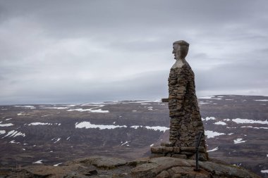 Westfjords, İzlanda, 24.05.2022. Kleifabui adam heykeli Kleifaheidi geçidinde, 1947 'de yol işçileri tarafından dikilmiş arka planda Westfjords dağ manzarası ile.