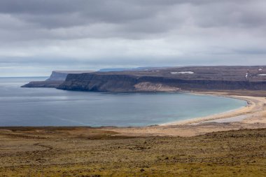 Breidavik altın plajı ve körfez manzarası arka planda dikey uçurumlar, bahar, Westfjords, İzlanda.
