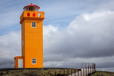 Svortuloft Deniz feneri (Svortuloft Lighthouse), Snaefellsnes yarımadasının en batı ucundaki parlak turuncu deniz feneri, İzlanda 'da turistler için ahşap yürüme platformları ve etrafındaki siyah volkanik kayalar.