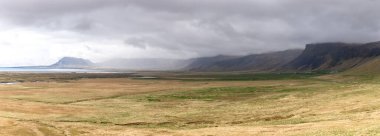 Snaefellsjokull glacier and Snaefellsnes peninsula coast panorama with cloudy mountain tops and grasslands, Iceland. clipart