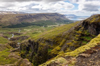 Glymur Kanyonu ve Hvalfjordur manzara manzarası Vesturland, İzlanda 'da, yeşil dağlar, dolambaçlı Botnsa nehri ve deniz manzarası uzakta, Glymur şelalesi yürüyüş patikasından görülüyor..