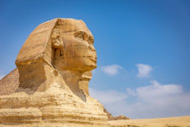 Giza Platosu, Mısır 'da Giza' nın büyük sfenksi, insan kafası ve aslan gövdesi olan bir yaratık, devasa kireçtaşı heykel, mavi gökyüzüne karşı profil görüntüsü..