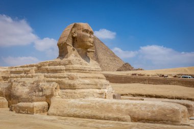 Giza Platosu, Mısır 'daki Büyük Giza Sfenksi, insan kafalı ve aslan gövdeli yaratık, arka planında piramit olan devasa kireçtaşı heykeli..