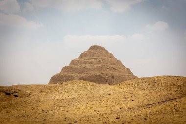 Mısır 'ın Saqara Necropolis kentindeki Djoser Piramidi (Djoser Piramidi, Horus Neterikhet' in Adım Piramidi) kum tepeleri arasında..