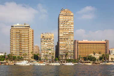 Giza, Mısır, 25.07.21. Giza şehri kıyı şeridi. İhmal edilmiş konut binaları ve Nil kıyı şeridi boyunca apartman blokları, Nasser 'in evi, kıyı boyunca tekne rıhtımı, Kahire, Mısır..