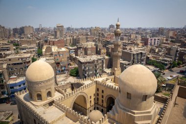 Kahire, Mısır, 26.07.21. Amir Sarghatmish Camii 'nin Madrasah' ı. Duvarları, kubbeleri ve minaresi oyulmuş. Arka planda Kahire 'nin İbn-i Tulun Camii' nden görülüyor..