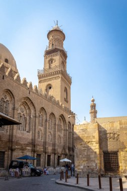 Kahire, Mısır, 26.07.21. Qalawun 'un üç katlı dekoratif minare ve taş cepheli, kavisli, açık oymalı pencere kapılarıyla Muizz caddesindeki kompleksinin manzarası.