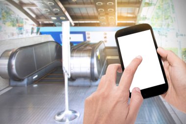 business man use mobile phone for Reservations train ticket to the city with escalator of the subway station in modern building with sunshine background.