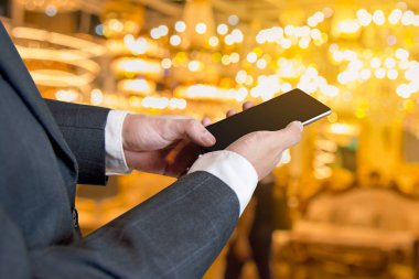 Bulanık altın sarısı arka plan, iş ve iletişim üzerinde akıllı telefon aygıtı kullanan bir işadamı.