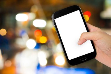 Hand hole smartphone on colorful abstract blurred background for design in empty screen.