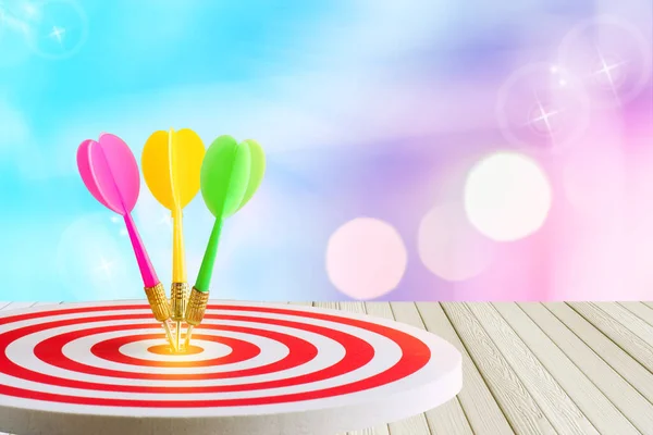 selective focus dart hitting in target center of dartboard,competitive business concept and abstract circular bokeh abstract light background