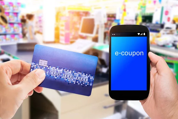 Hand Holding Mobile Phone Credit Card Supermarket Checkout Background Coupon — Fotografia de Stock
