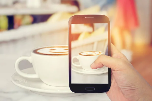Smile Latte Coffee on the table in reataurant with sunshine background.(concept vintage tone)