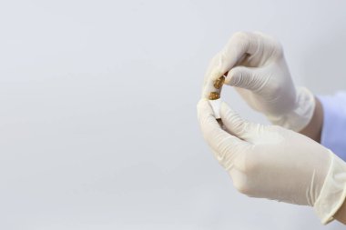 Doctor's hand in white sterilized surgical glove open a bottle of medicine.