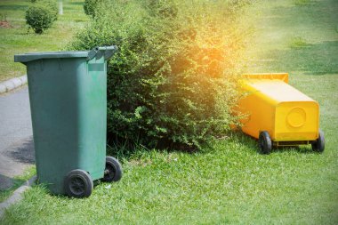 Yellow and green trash bin from a public park.