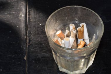 Cigarette in a glass on the table.