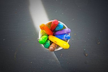 multi color chalk oil pastel in green cup on black background