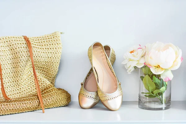 Pair of gold casual shoes with gold bag and rose flower for women.