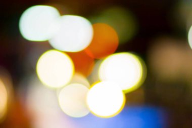 image of blur street and billboard with warm colorful lights in night time for background usage .