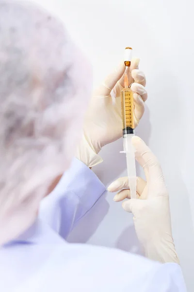 Şırınga, elinde tıbbi enjeksiyon, avuç içi ya da parmak. İğneli tıbbi plastik aşı ekipmanı. Hemşire ya da doktor. Sıvı uyuşturucu ya da uyuşturucu. Hastanede sağlık hizmeti.