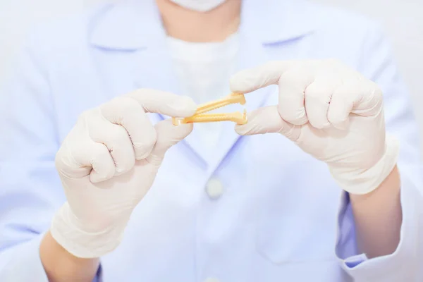 Yellow umbilical cord clamp used to clamp off the umbilical cord after a baby's birth.