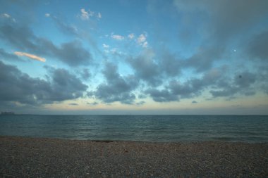 Deniz manzarası ve mavi gökyüzü. Gün batımının ışığında bulutlar.