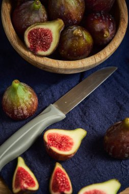 Durgun bir hayat ve tahtadan bir masada dilimlenmiş incir meyvesi.